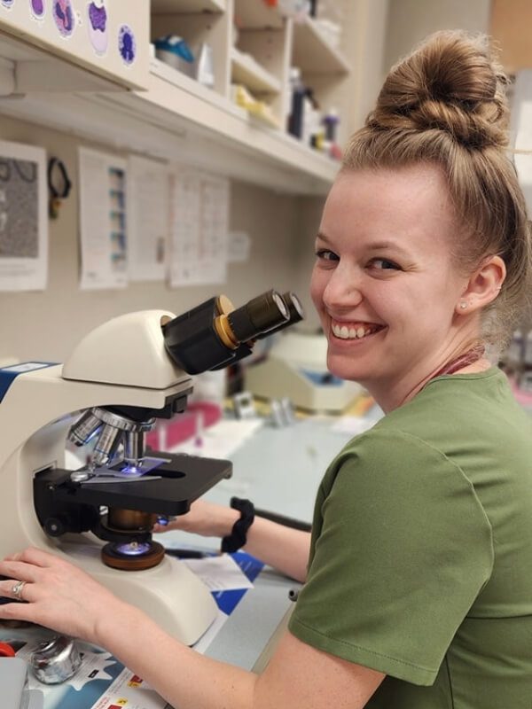 Female Smiling By Microscope